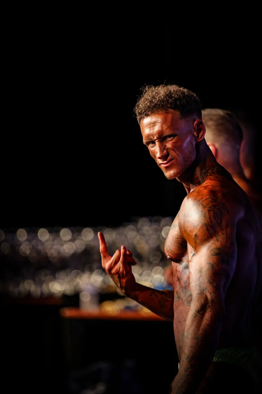 Athlete flexing in dramatic side light backstage